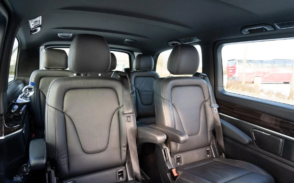 На фото изображен просторный салон Mercedes-Benz EQV с тремя рядами сидений. 